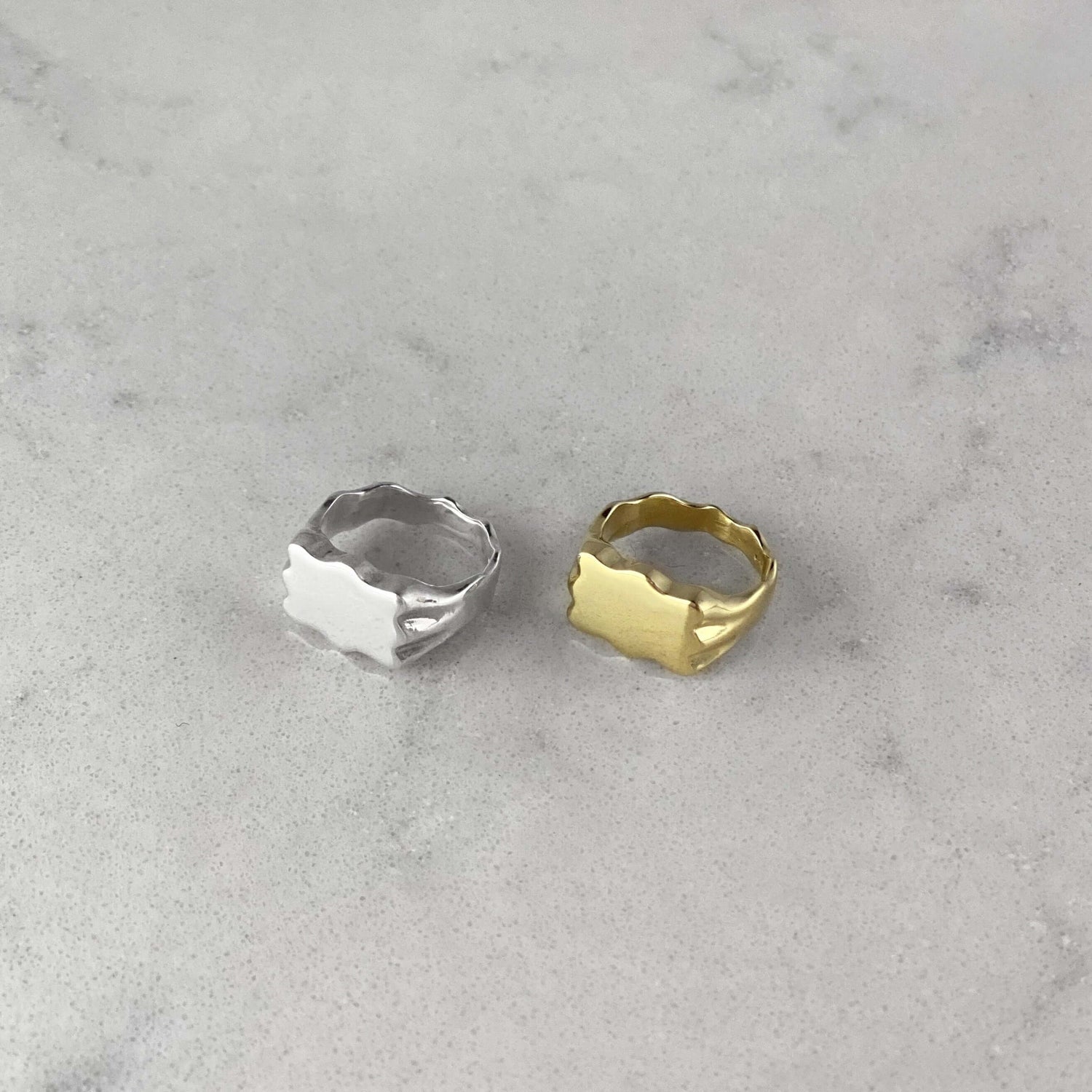 Product photo of two signet rings, one in silver and one in gold