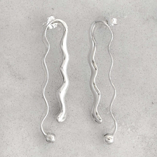 Product photo of a pair of silver earrings on a marble plate