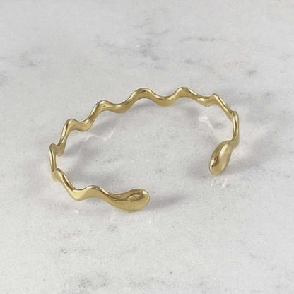 Product photo of a gold bracelet on a marble plate