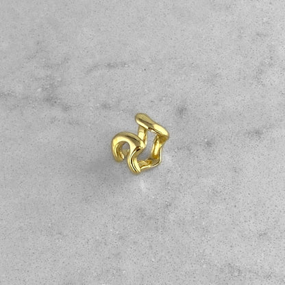 Gold ear cuff on a marble table