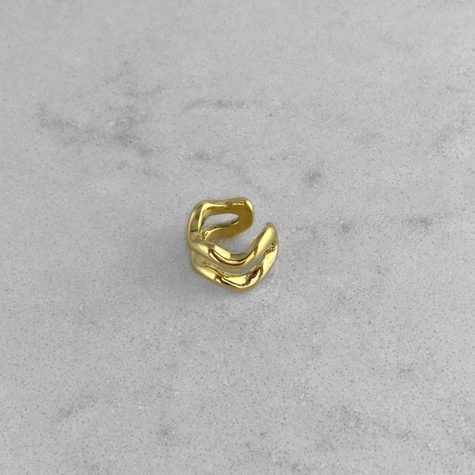 Gold ear cuff on a marble table