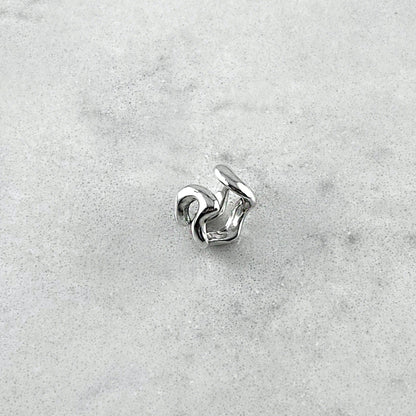 Silver ear cuff on a marble table