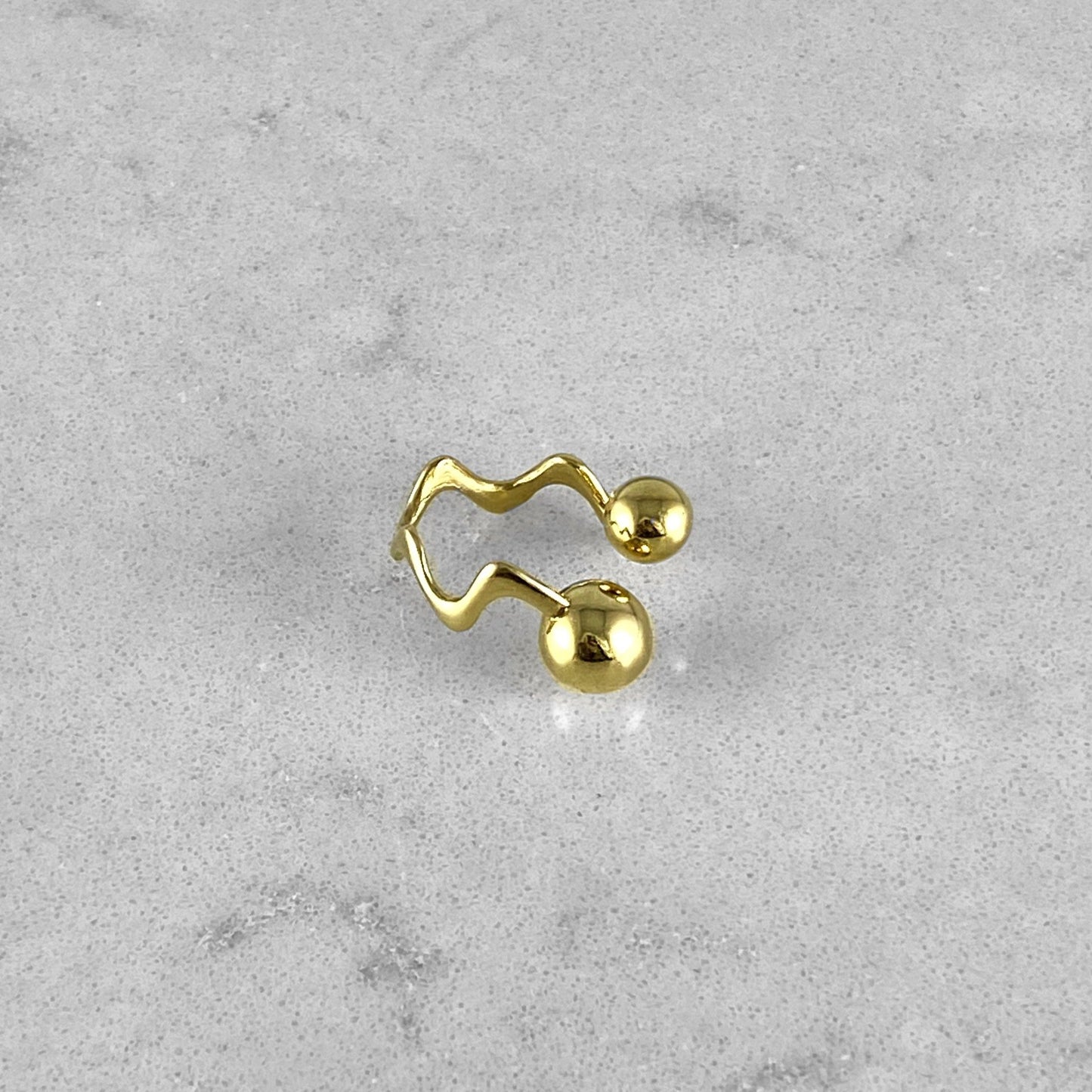 Product photo of a gold ring laying on a marble plate